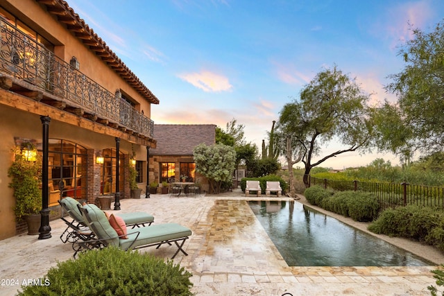 exterior space featuring a fenced in pool and a balcony