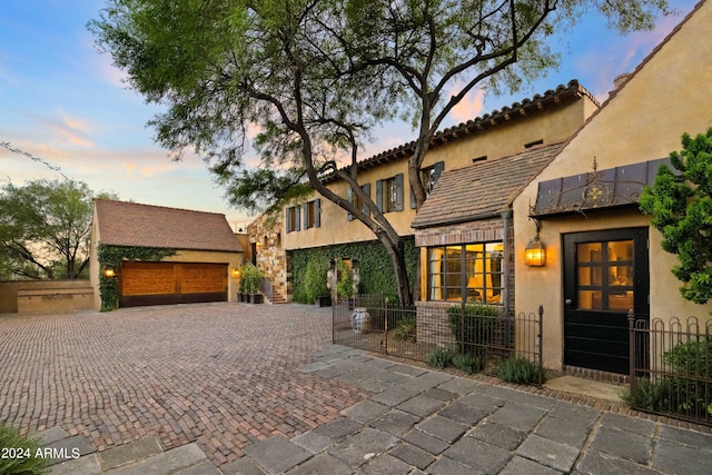 mediterranean / spanish-style home with stucco siding and fence