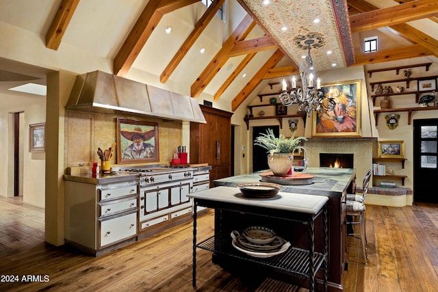 dining room featuring beam ceiling, high vaulted ceiling, hardwood / wood-style floors, a lit fireplace, and a chandelier