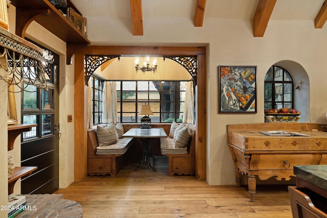 office space with beam ceiling, arched walkways, an inviting chandelier, and wood finished floors