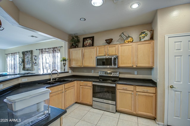 kitchen featuring appliances with stainless steel finishes, sink, light tile patterned floors, and light brown cabinetry