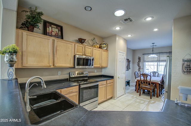 kitchen featuring light tile patterned flooring, appliances with stainless steel finishes, pendant lighting, light brown cabinetry, and sink