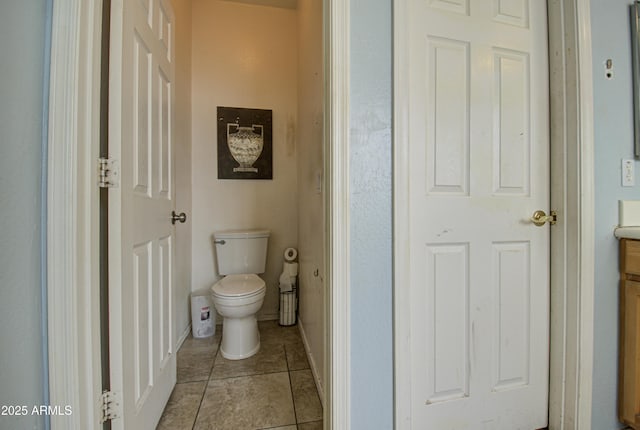 bathroom with tile patterned flooring, vanity, and toilet