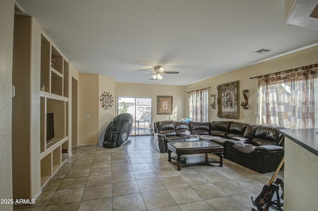 tiled living room featuring a textured ceiling and ceiling fan