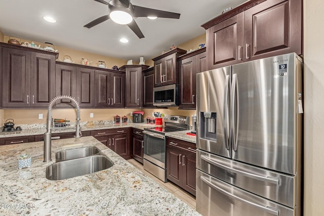 16259 W Papago St, Goodyear, AZ 85338 - kitchen featuring stainless steel appliances, dark brown cabinets, a ceiling fan, light stone countertops, and recessed lighting