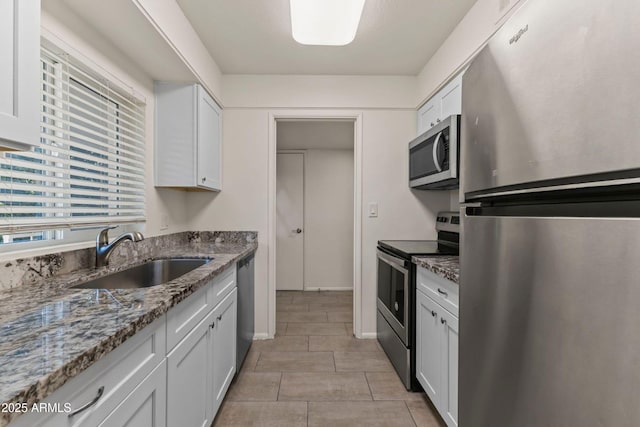 kitchen featuring stone countertops, sink, white cabinets, and appliances with stainless steel finishes