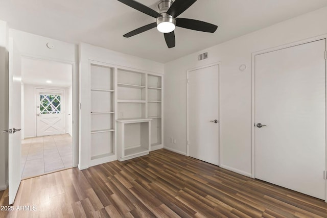 unfurnished bedroom with dark wood-type flooring and ceiling fan