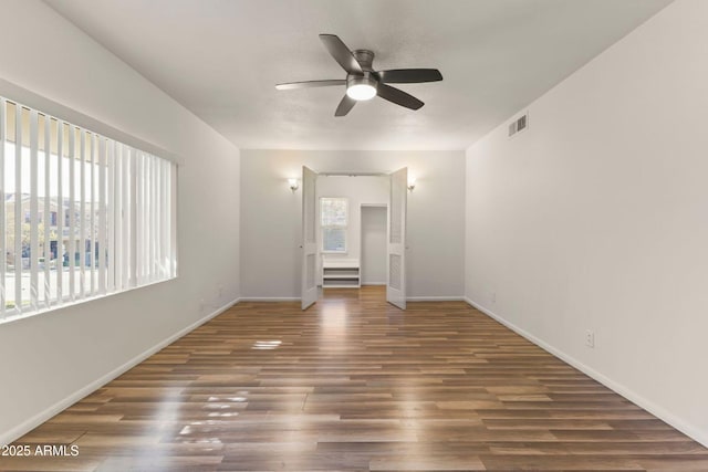 spare room with dark wood-type flooring and ceiling fan