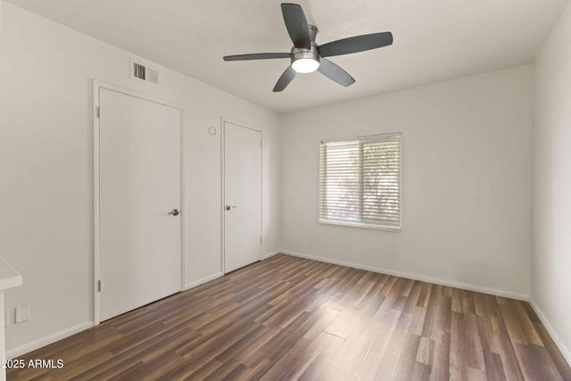 unfurnished bedroom with dark wood-type flooring and ceiling fan