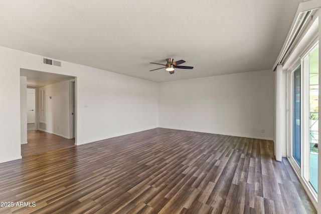 empty room with dark hardwood / wood-style floors, a textured ceiling, and ceiling fan