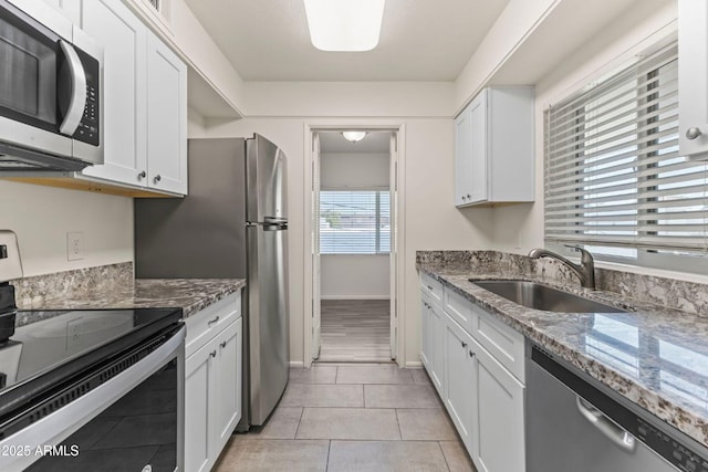 kitchen featuring stone countertops, appliances with stainless steel finishes, sink, and white cabinets