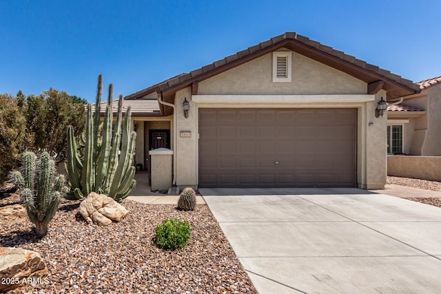 view of front of house with a garage, concrete driveway, and stucco siding