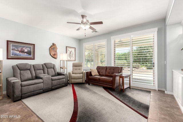 living room featuring ceiling fan, tile patterned floors, and baseboards