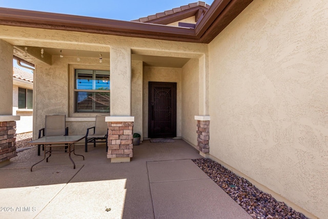 doorway to property with stucco siding and stone siding
