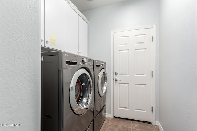 laundry room featuring washer and clothes dryer, cabinet space, baseboards, tile patterned flooring, and a textured wall