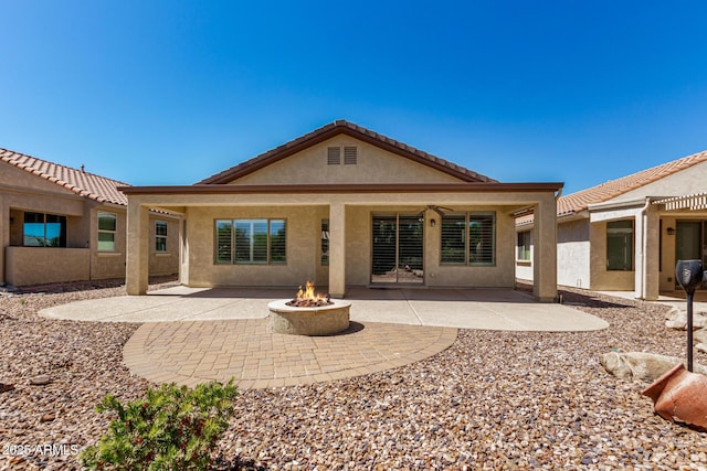 back of property featuring a fire pit, stucco siding, and a patio