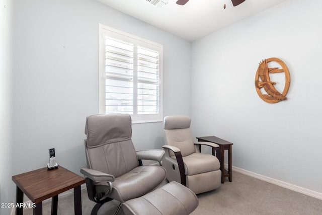 sitting room with a ceiling fan, light carpet, and baseboards