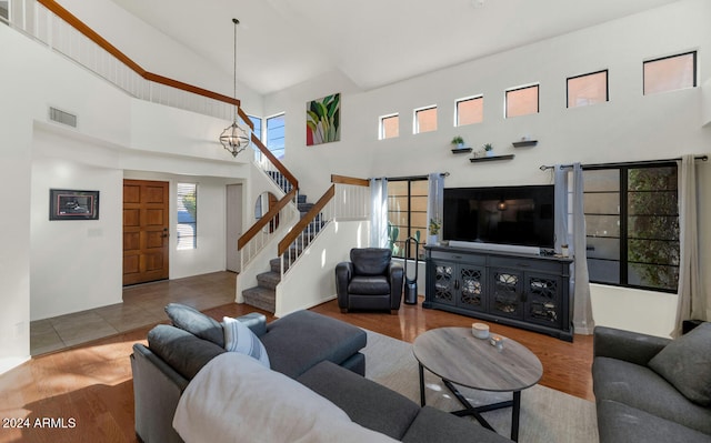 living room featuring wood-type flooring and a towering ceiling