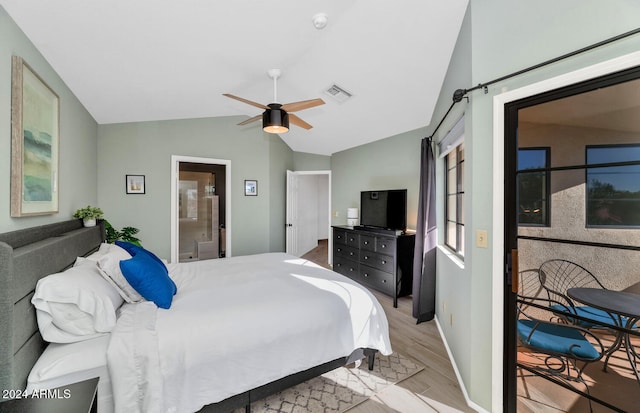 bedroom featuring ceiling fan, light hardwood / wood-style floors, ensuite bath, and vaulted ceiling