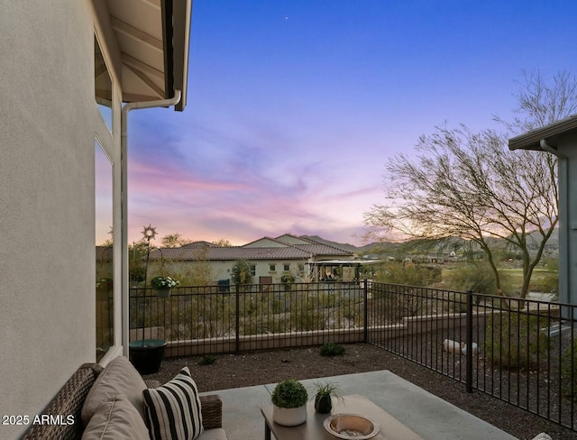 patio terrace at dusk featuring fence