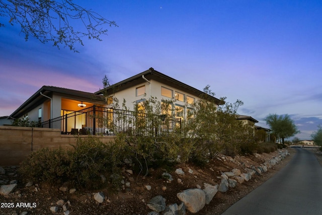 view of home's exterior with stucco siding and fence