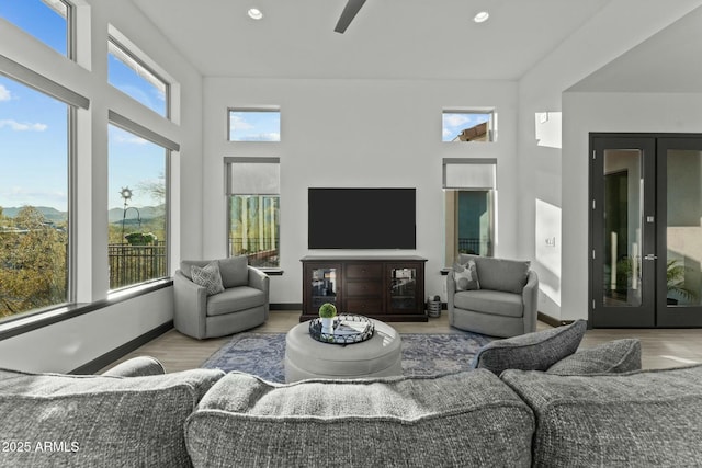 living room with recessed lighting, french doors, baseboards, and wood finished floors