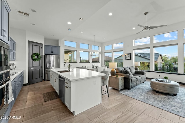 kitchen with visible vents, stainless steel appliances, light countertops, and a sink