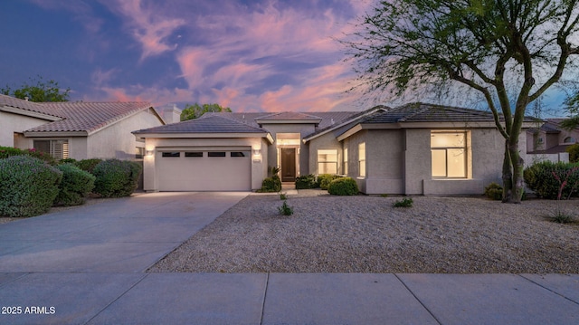 5103 E Juniper Ave, Scottsdale, AZ 85254 - view of front of home featuring a garage, concrete driveway, stucco siding, and a tile roof