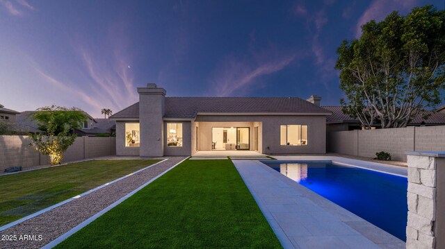 5103 E Juniper Ave, Scottsdale, AZ 85254 - back of property at dusk featuring a chimney, a tiled roof, a patio, and stucco siding