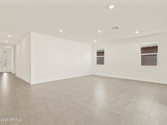 spare room featuring light tile patterned floors and a wealth of natural light