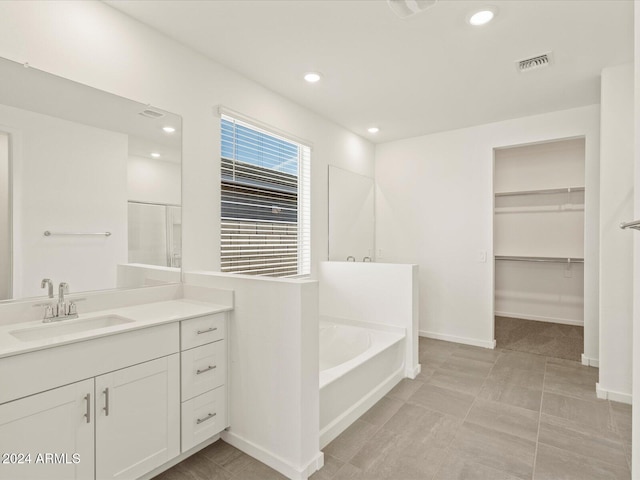 bathroom with vanity and separate shower and tub