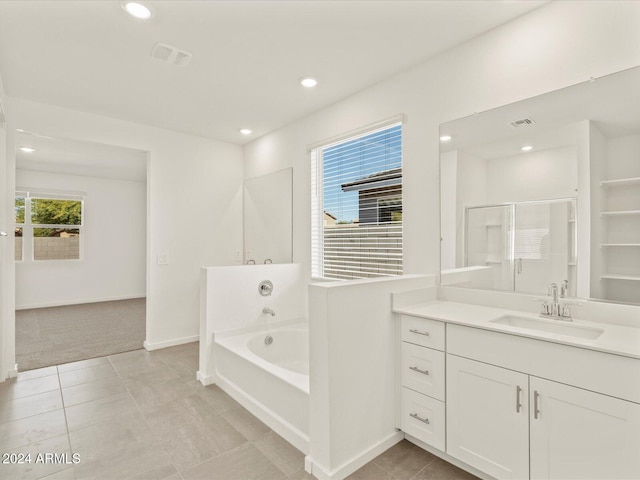 bathroom with tile patterned flooring, shower with separate bathtub, vanity, and plenty of natural light