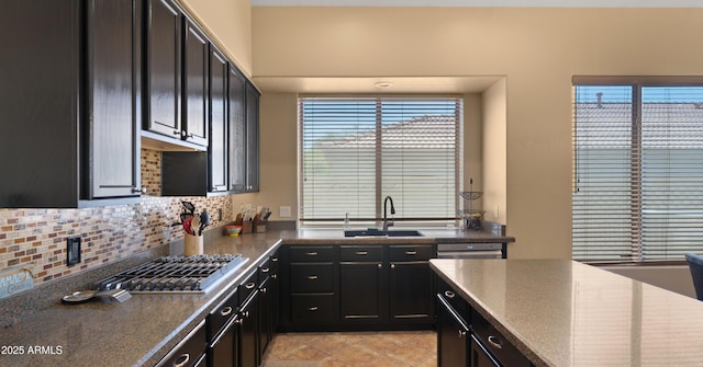 13614 N 12th Way, Phoenix, AZ 85022 - kitchen featuring dark cabinetry, decorative backsplash, stainless steel gas stovetop, and a sink