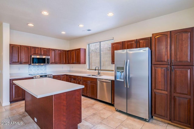 kitchen featuring tasteful backsplash, sink, stainless steel appliances, and a center island