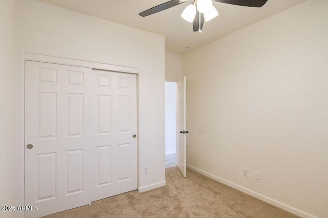 unfurnished bedroom featuring light carpet, ceiling fan, and a closet