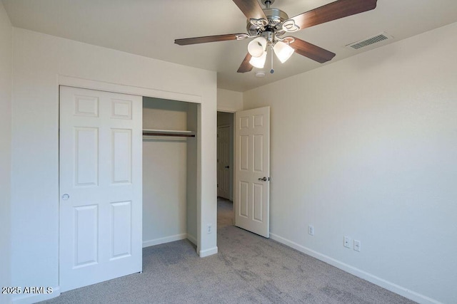 unfurnished bedroom with light colored carpet, ceiling fan, and a closet