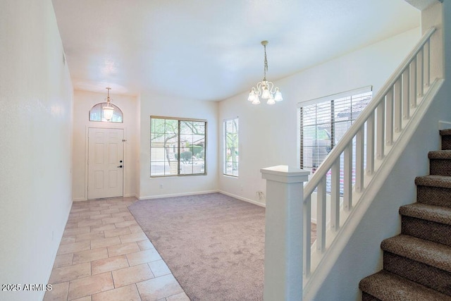 carpeted foyer entrance with a chandelier