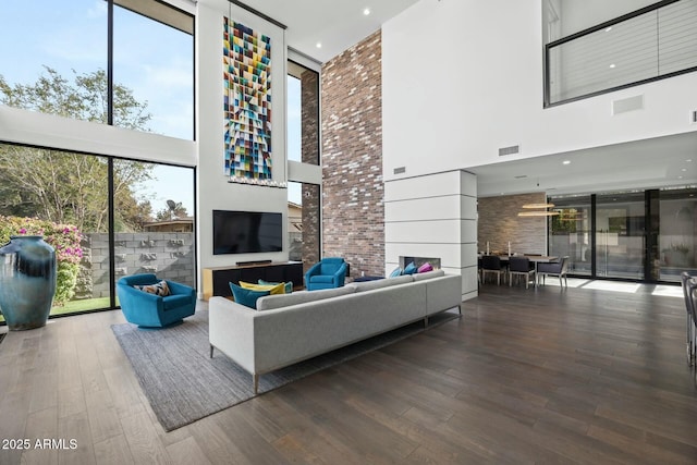 living room featuring a wealth of natural light, wood-type flooring, and a high ceiling