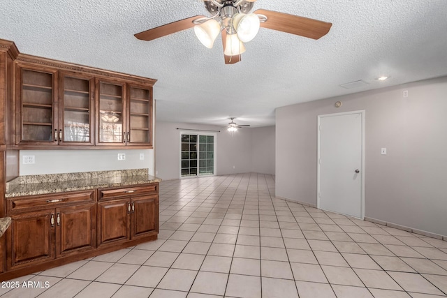 6837 W Camelback Rd, Phoenix, AZ 85033 - kitchen featuring a ceiling fan, a textured ceiling, open shelves, brown cabinetry, and glass insert cabinets