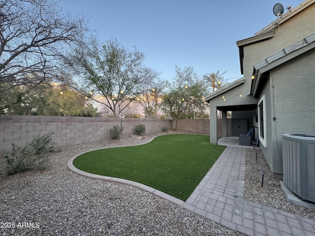 view of yard with a patio area, a fenced backyard, and central air condition unit