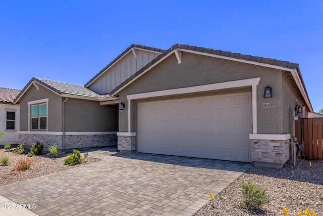 40499 W Michaels Dr, Maricopa, AZ 85138 - view of front of house featuring stone siding, a tile roof, decorative driveway, and an attached garage