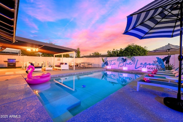 8243 E Montecito Ave, Scottsdale, AZ 85251 - pool at dusk featuring a patio area, area for grilling, a fenced backyard, an outdoor living space, and a fenced in pool