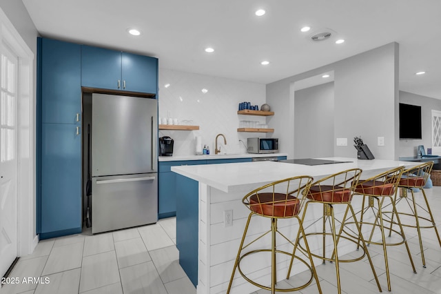 8243 E Montecito Ave, Scottsdale, AZ 85251 - kitchen with a kitchen bar, appliances with stainless steel finishes, blue cabinets, and open shelves