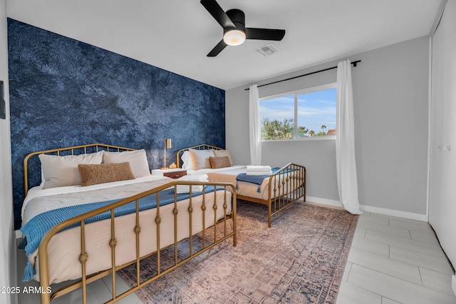 8243 E Montecito Ave, Scottsdale, AZ 85251 - bedroom featuring baseboards, wallpapered walls, a ceiling fan, an accent wall, and visible vents