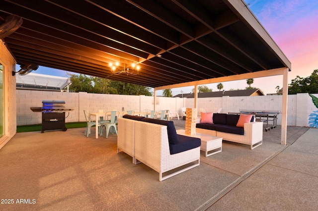 8243 E Montecito Ave, Scottsdale, AZ 85251 - patio terrace at dusk featuring grilling area, outdoor dining space, an outdoor hangout area, and a fenced backyard
