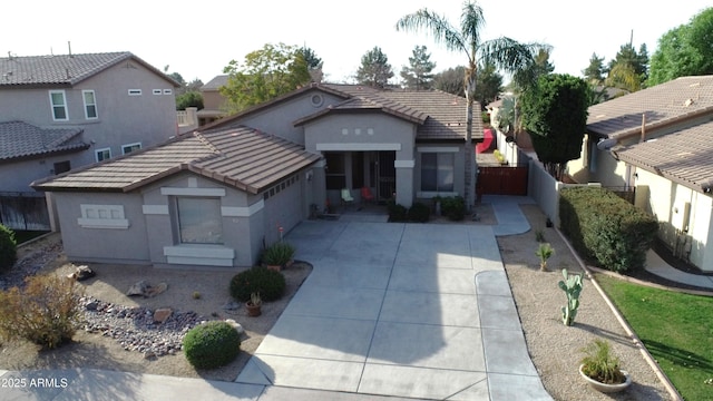 view of front facade with a garage, stucco siding, concrete driveway, and a tiled roof