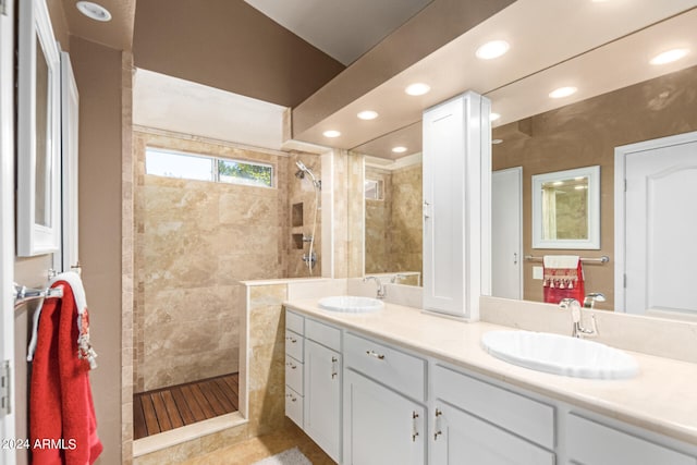 bathroom featuring a tile shower, vanity, and tile patterned floors