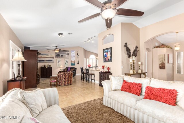 tiled living room featuring sink, ceiling fan, rail lighting, and vaulted ceiling