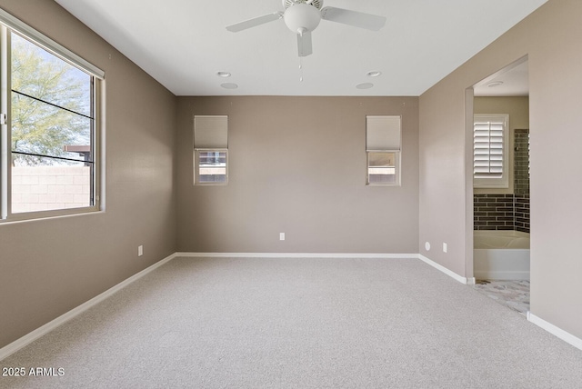 carpeted spare room with baseboards and a ceiling fan