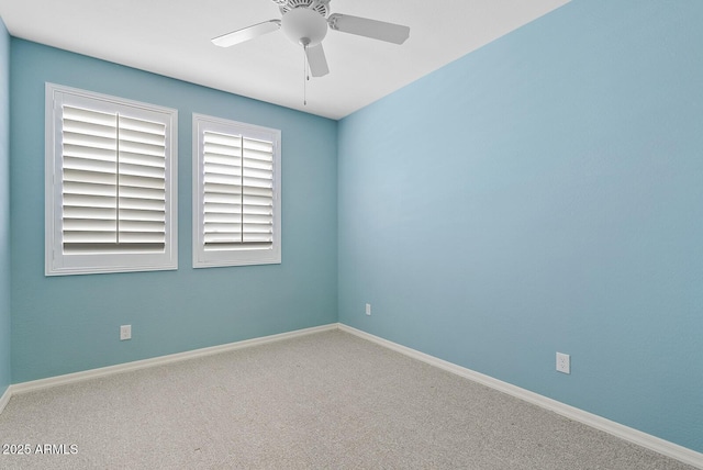 carpeted empty room featuring baseboards and ceiling fan